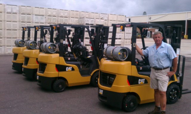 West Coast Tomato GM Don Hall poses proudly with the first four Cat lift trucks delivered in September, lined up and ready to go to work. 